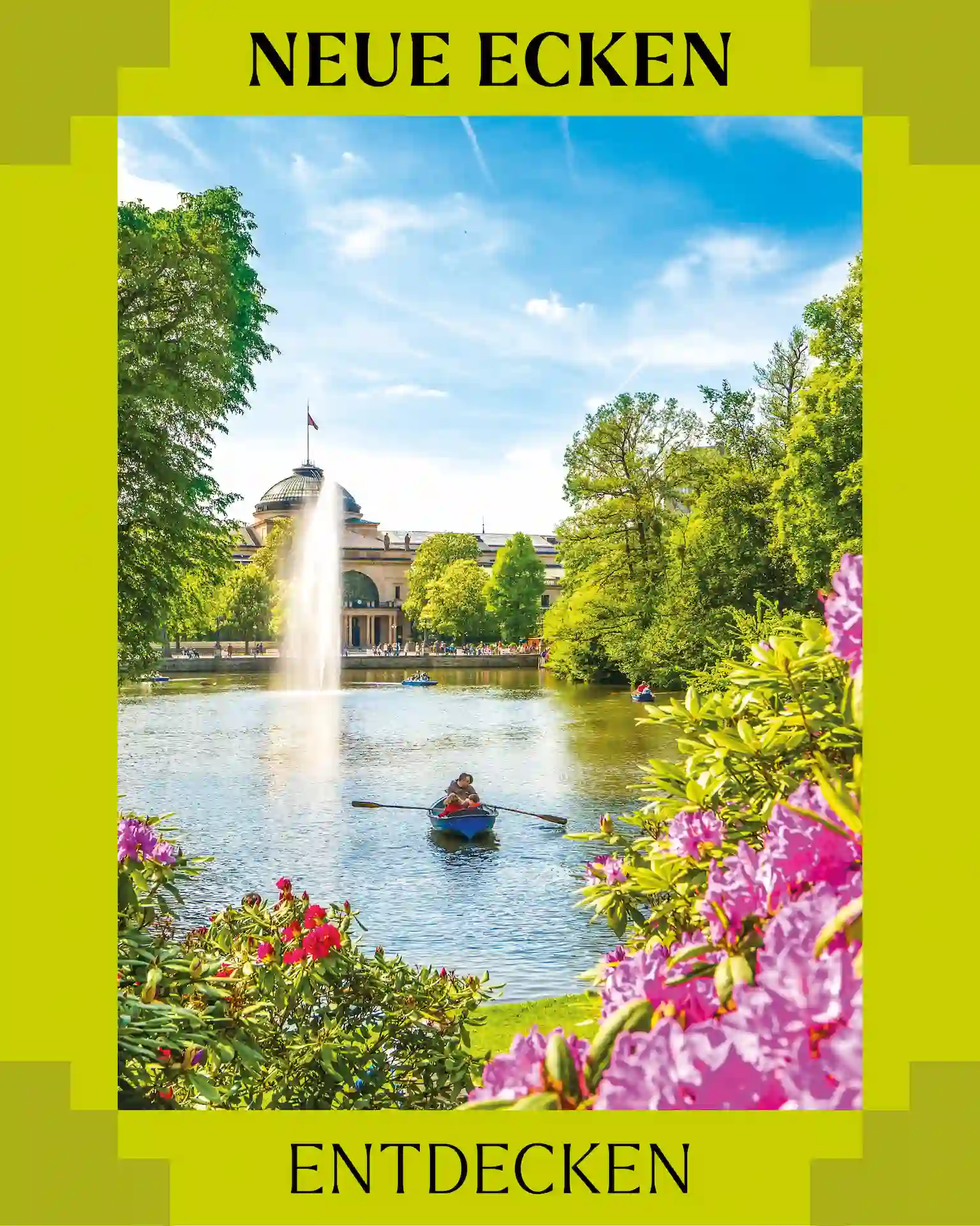 Hellblauer Himmel. ein See mit 2 Paddelbooten und Springbrunnen dahinter ein Gebäude. Vorne auf dem Bild sind Blumensträucher mit pinken und roten Blüten